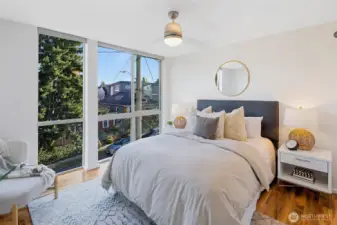 At the end of the hall, the spacious primary suite offers a relaxing retreat with stunning south-facing windows and endless natural light.
