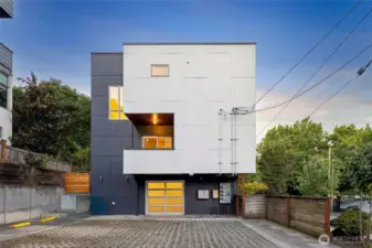 Rear exterior of the townhouse, highlighting its modern design and private garage entrance.
