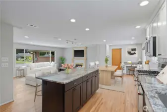 Stunning remodeled kitchen featuring beautiful hardwood floors, a large island with bar seating, and gourmet finishes. Equipped with sleek stainless-steel appliances, a gas cooktop, and gorgeous cabinets and countertops., this space offers great storage and ample workspace. Complete with stylish tile backsplash, it's perfect for entertaining guests. ADA Accessible