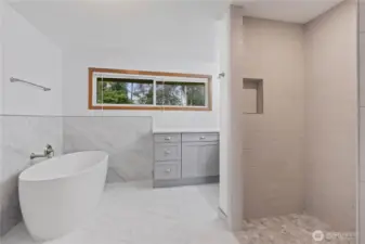 Gorgeous, completely remodeled primary bathroom featuring a spa-like atmosphere with a luxurious walk-in shower, soaking tub, and a beautiful vanity with elegant countertops. Tile floors and stylish finishes create the perfect retreat for relaxation and pampering. ADA Accessible