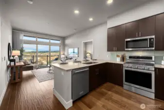 A bright, open kitchen with a view, seamlessly flowing into the living space—perfect for entertaining while enjoying the scenery just beyond your windows.