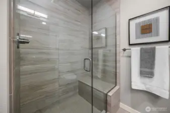 A stunning floor-to-ceiling tiled shower with a sleek, modern design, enhanced by a built-in niche for your bath essentials.