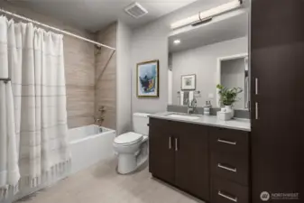 Secondary bathroom featuring a spacious vanity, a tiled shower/tub combo, and plenty of storage for all your essentials.