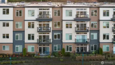 A closer exterior view highlighting the unit itself, showing its private entry, balcony, and architectural details within the beautifully designed complex.