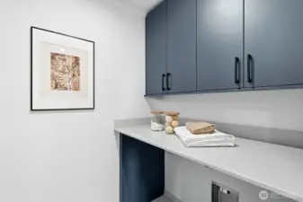 Upstairs laundry room fits a side-by-side W/D + additional storage.