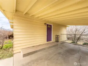 Covered carport with additional storage space and convenient access to the home.