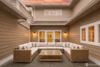 Enclosed entry courtyard creates a private, welcoming outdoor living space, ideal for relaxing or gathering, with direct access to the home. - virtually staged