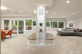 Double-sided gas fireplace serves as a striking focal point, creating a warm connection between the living room and dining area while enhancing the open-concept layout.