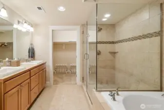 Primary bathroom with ceramic tile counters, floors, and an oversized walk-in shower, complemented by a Jacuzzi tub.