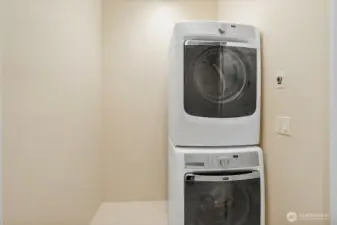 Laundry closet with stackable washer and dryer, allowing for additional storage space for cleaning supplies, vacuum, and everyday essentials.