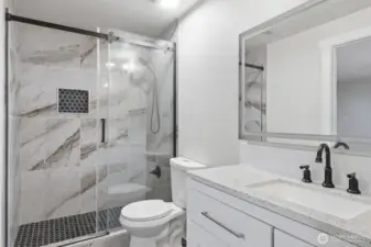 1 of 2 bathrooms that both offer gorgeous tile showers and glass doors.