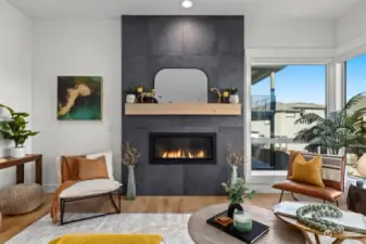 Gas fireplace with wood mantel and floor to ceiling tiling.