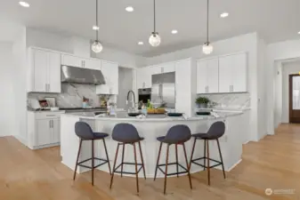 Oversized kitchen island with slab quartz countertops is the crown jewel of this true chef's kitchen.