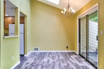 The living room flows into the dining area with skylight and slider to backyard patio.