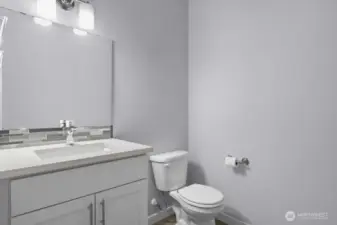 Powder bath tucked away behind kitchen.