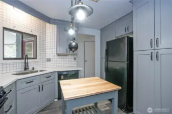 From the kitchen, look into the hallway off the back door, where the walk-in pantry is conveniently located around the corner.