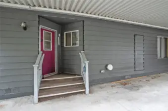 Covered carport featuring a back door for easy access.