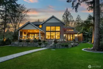 Expansive windows look out at the one acre parcel and protected land beyond.