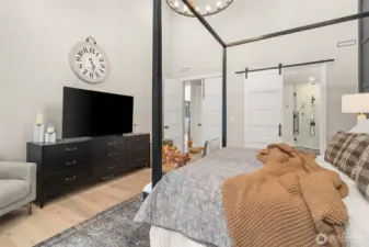 The large primary bedroom complete with a chandelier.