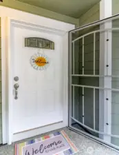 An inviting front door with a locking screen door.