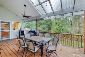covered deck overlooking park-like backyard.