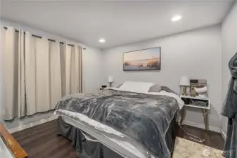 Unit 2 - Bright primary bedroom featuring updated flooring, recessed lighting, and a large closet for convenient storage. Neutral paint and natural light create a welcoming retreat within this versatile duplex home.