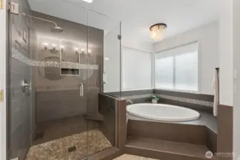 Primary ensuite bath view two showing separate soaking tub and walk-in shower with handy seat! An OASIS.