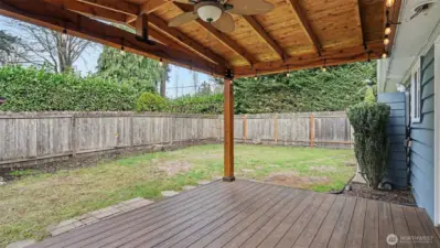 Cozy covered back porch features outdoor ceiling fan for year around enjoyment.