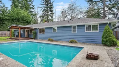 Cozy covered back porch features outdoor ceiling fan for year around enjoyment.