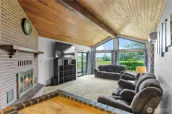 Living room with vaulted ceiling w/center beam and chalet style windows overlooking the beautiful view!