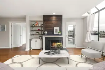 Beautiful accent fireplace, with reclaimed wood on upper part of fireplace, with wood mantel and black painted tile around face. Wood burning.