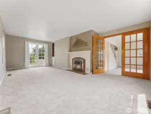 Large living room w/cozy fp and door leading to patio