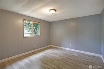 Spacious first bedroom with new flooring and fresh paint.