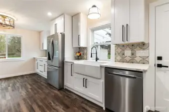 The cabinet to the right of the refrigerator is a hidden trash and recycle cabinet.