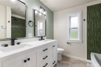 Beautifully appointed bathroom with double shower heads and double sinks. Lots of storage to the left of the sink and in vanity.