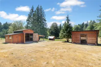 Views of the large wood shed, barn with double doors and chicken coop in the distance