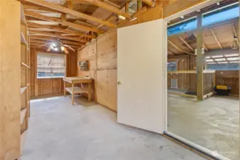 Tack room with shelving, work bench and 2 windows.