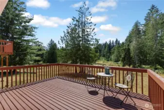 Back deck with views of property and steps that lead down to yard