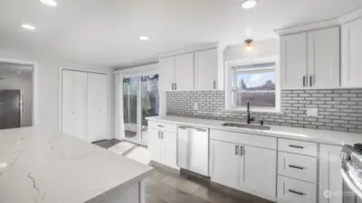 This fully updated kitchen boasts stainless steel appliances, crisp white cabinetry, quartz countertops & a timeless backsplash.