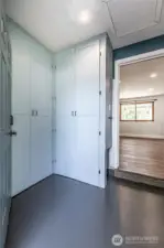 View into mud room from exterior entry door showing additional cabinets and into family room.
