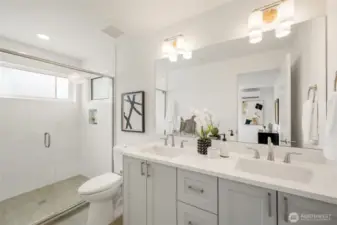 Walk-in tile shower and double sinks.
