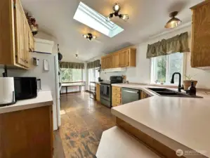 Kitchen with eating space, coffee nook, airy atmosphere, and abundant daylight from numerous windows."