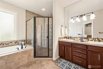 Spa-inspired ensuite with soaking tub, fully tiled shower, and double vanity.