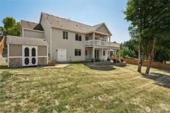 Large fenced backyard with a coordinating storage shed and a sprawling lawn for endless outdoor enjoyment.