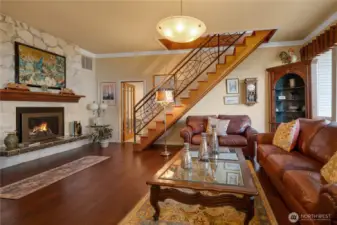 Custom iron banister to upstairs bonus room flanks the gorgeous living room w/gas fireplace.