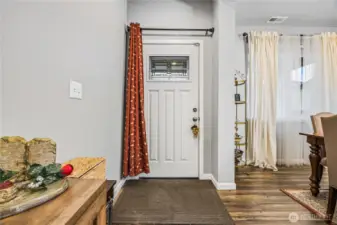 Welcoming front entry with decorative glass detail and natural light. \