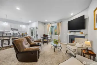 Bright and spacious living room featuring carpet, recessed lighting, and a gas fireplace