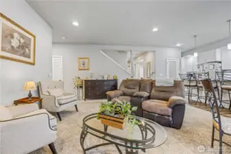 Open concept living area connecting to the kitchen and dining space with easy access to guest bathroom, guest bedroom, garage and stairs