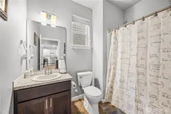 Modern main floor guest bathroom with neutral finishes, full tub/shower combo, and updated fixtures.