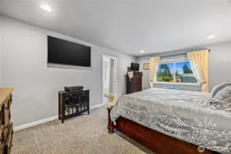 Spacious primary suite with a large window overlooking the backyard.
